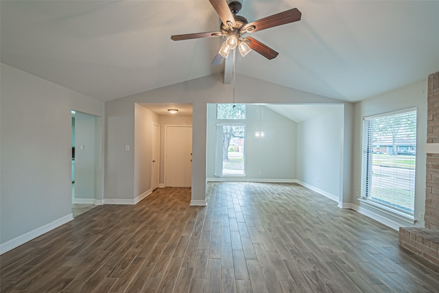 unfurnished living room featuring plenty of natural light, ceiling fan, dark wood-type flooring, and lofted ceiling with beams