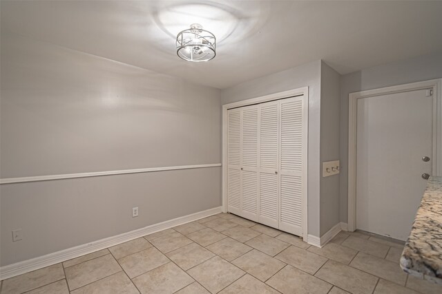 unfurnished bedroom featuring a closet and light tile patterned flooring