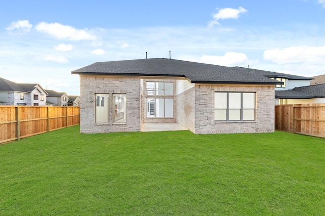 rear view of property with a yard and a patio area