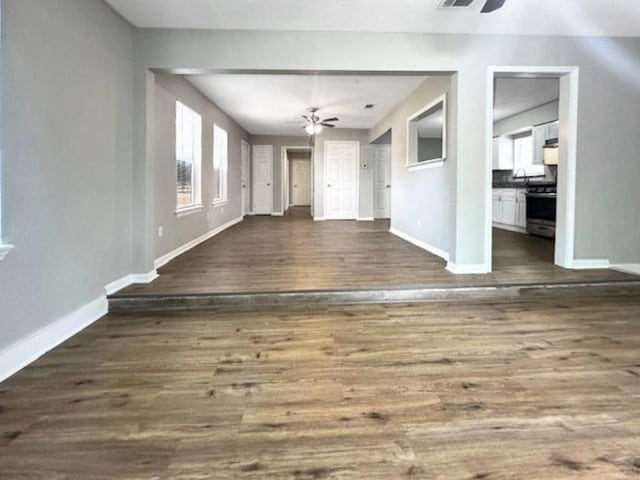 unfurnished living room featuring dark hardwood / wood-style floors and ceiling fan