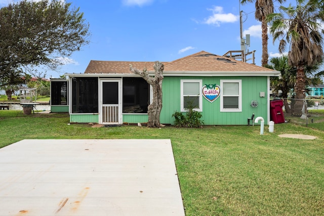 rear view of house featuring a sunroom and a yard