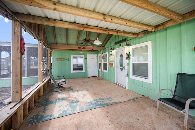 unfurnished sunroom with lofted ceiling with beams