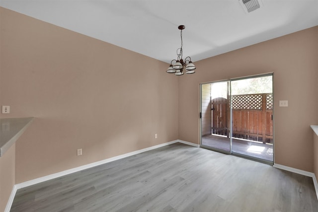 unfurnished dining area featuring hardwood / wood-style flooring and a notable chandelier