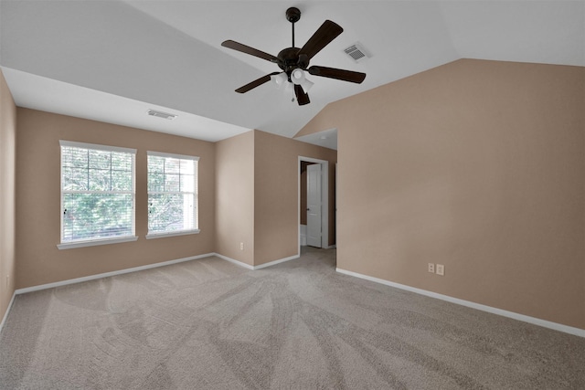 empty room featuring light carpet, vaulted ceiling, and ceiling fan