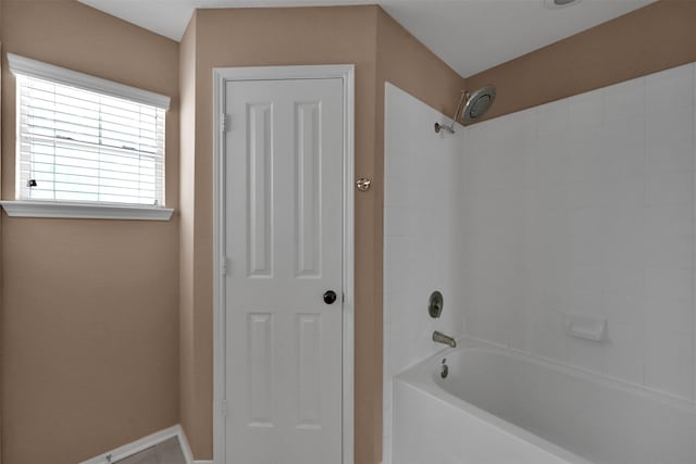 bathroom featuring washtub / shower combination and tile patterned flooring