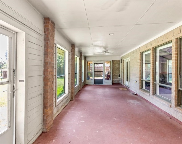 unfurnished sunroom featuring ceiling fan