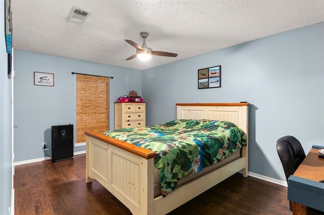 bedroom featuring dark hardwood / wood-style floors, ceiling fan, and a textured ceiling