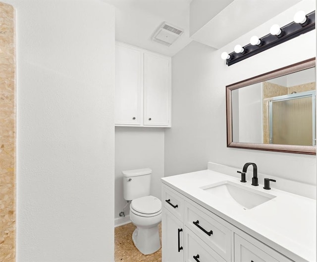 bathroom with vanity, a shower with shower door, and toilet