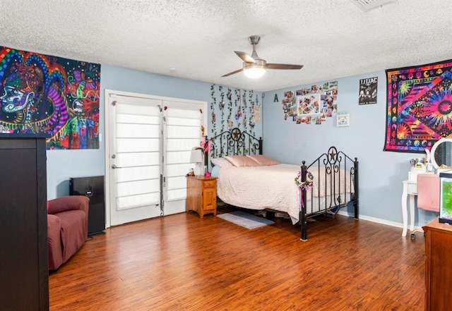 bedroom with hardwood / wood-style floors, a textured ceiling, and ceiling fan