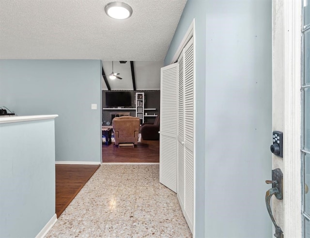 hallway featuring light wood-type flooring and a textured ceiling