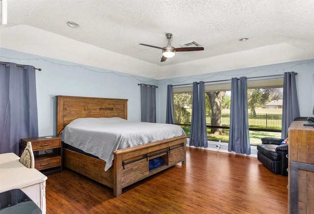 bedroom with a textured ceiling, access to outside, ceiling fan, and dark wood-type flooring