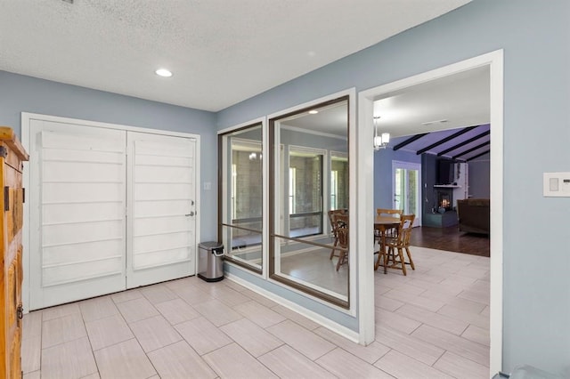 interior space featuring a textured ceiling, lofted ceiling with beams, and a notable chandelier