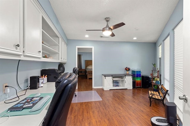 office space with ceiling fan, dark hardwood / wood-style flooring, and a textured ceiling