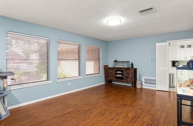 interior space with a textured ceiling and dark hardwood / wood-style floors