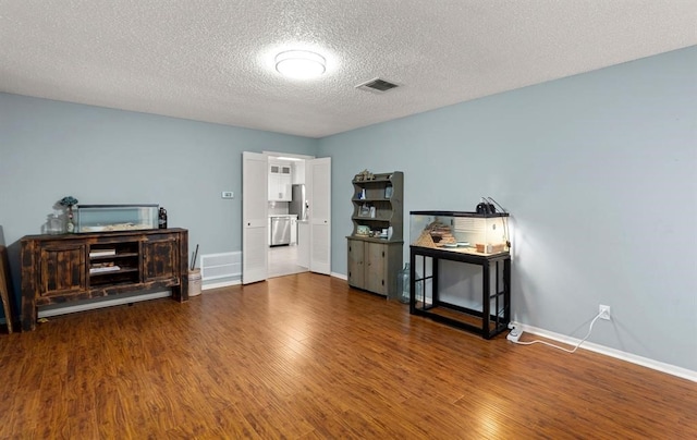 misc room featuring wood-type flooring and a textured ceiling