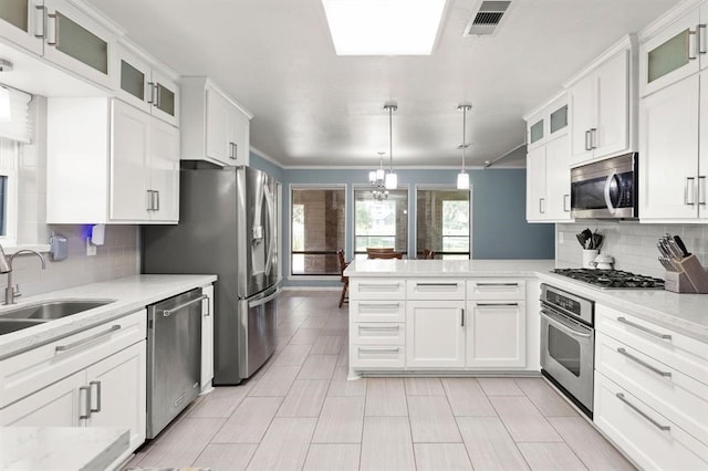 kitchen with pendant lighting, white cabinetry, sink, and appliances with stainless steel finishes