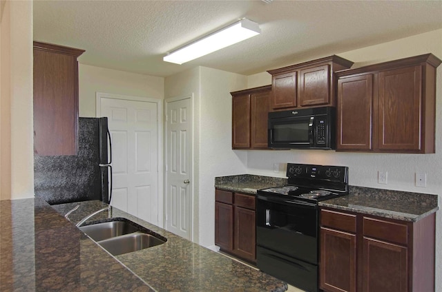 kitchen with black appliances, sink, a textured ceiling, and dark stone counters