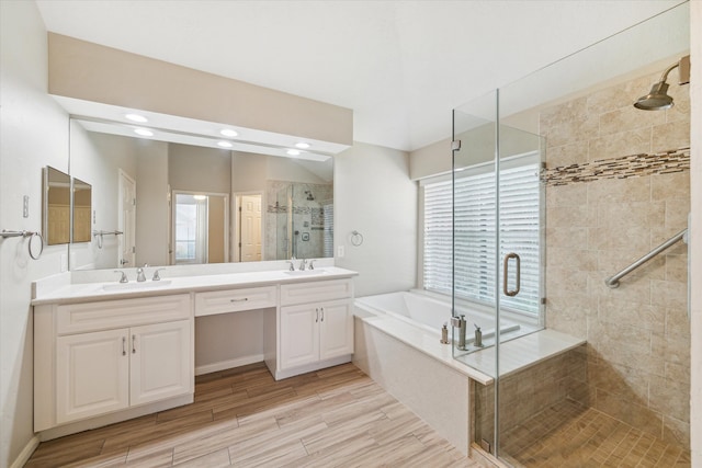 bathroom with independent shower and bath, vanity, and a healthy amount of sunlight