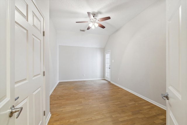 unfurnished room with ceiling fan, light wood-type flooring, and vaulted ceiling