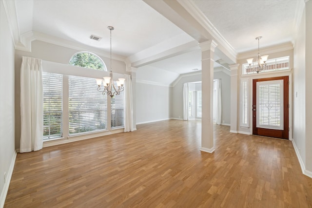 entrance foyer featuring ornate columns, ornamental molding, light hardwood / wood-style floors, and a notable chandelier