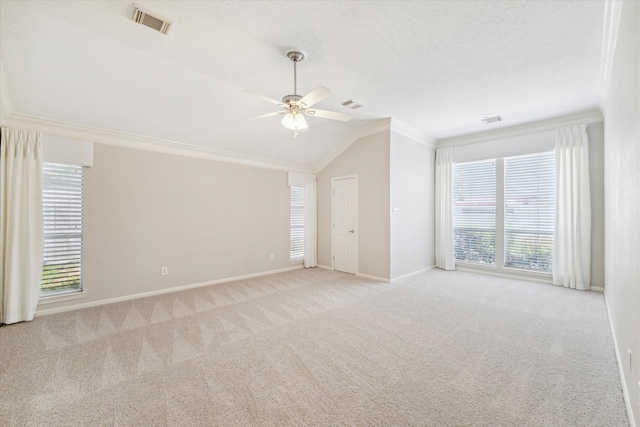 unfurnished room featuring ornamental molding, light carpet, a wealth of natural light, and vaulted ceiling