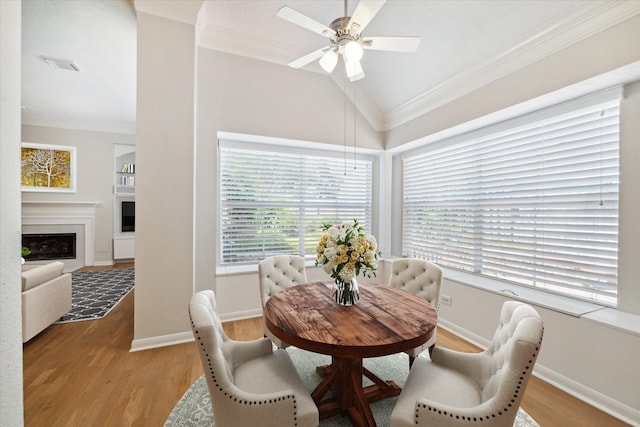 dining area featuring ceiling fan, lofted ceiling, ornamental molding, and light hardwood / wood-style flooring