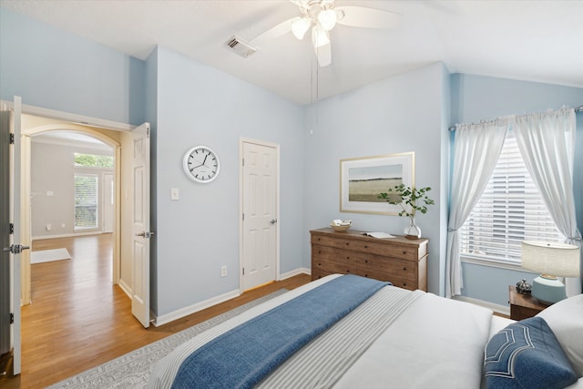 bedroom featuring ceiling fan, light hardwood / wood-style floors, and lofted ceiling