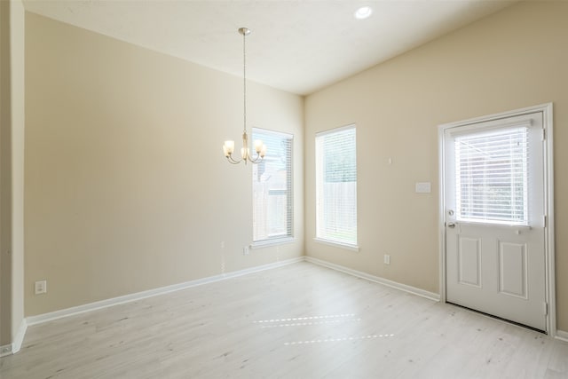 unfurnished dining area featuring a notable chandelier and light wood-type flooring