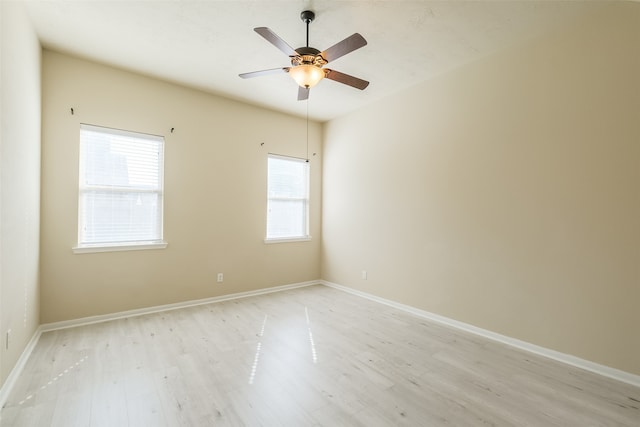 empty room with light hardwood / wood-style floors, ceiling fan, and a healthy amount of sunlight