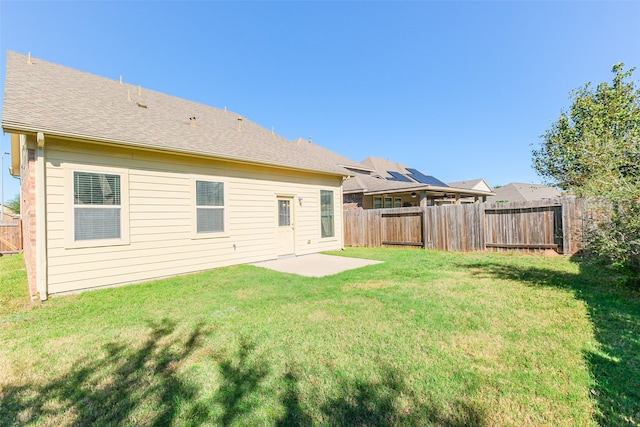 back of property with a lawn and a patio