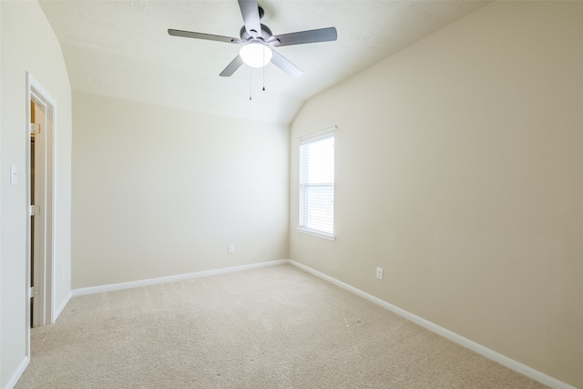 spare room featuring light carpet, ceiling fan, and lofted ceiling