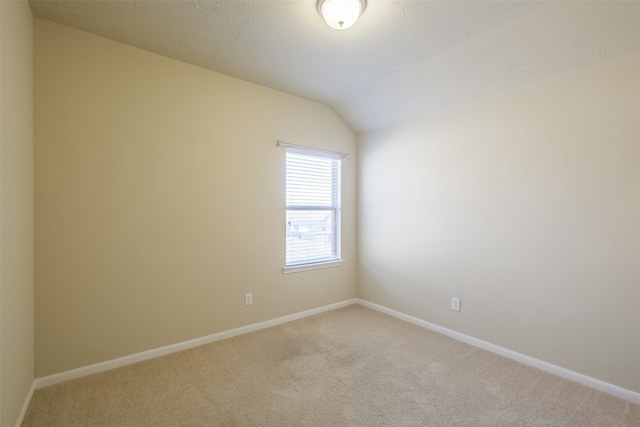 spare room with lofted ceiling and carpet floors