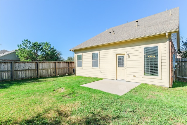 rear view of house featuring a yard and a patio