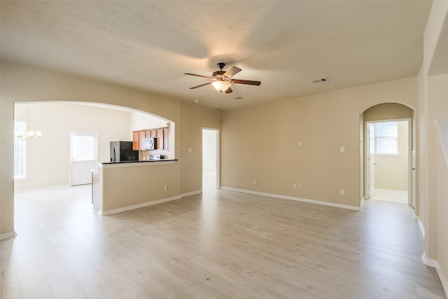 spare room featuring light hardwood / wood-style floors and ceiling fan with notable chandelier