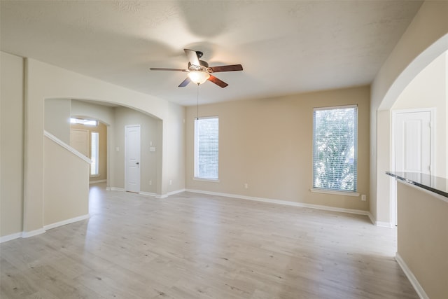 unfurnished room with light wood-type flooring and ceiling fan