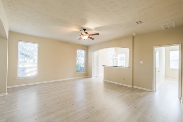 unfurnished room featuring ceiling fan, light hardwood / wood-style flooring, and a textured ceiling