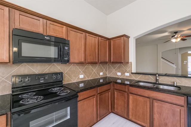 kitchen featuring black appliances, ceiling fan, sink, and dark stone counters