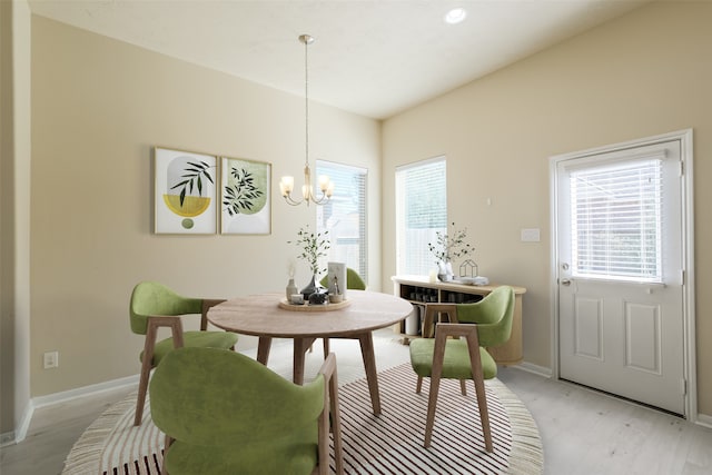 dining space with a notable chandelier, a healthy amount of sunlight, and light hardwood / wood-style flooring