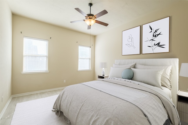 bedroom featuring multiple windows, ceiling fan, and light hardwood / wood-style floors