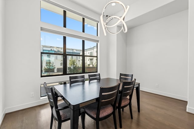 dining space featuring dark hardwood / wood-style flooring and an inviting chandelier