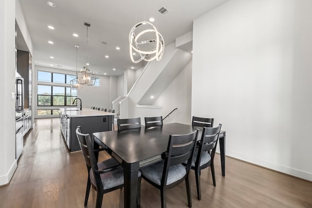 dining room with light hardwood / wood-style flooring and a notable chandelier