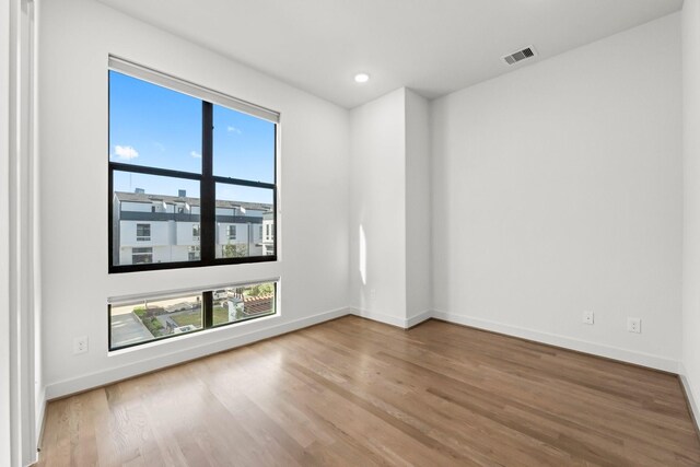 unfurnished room with hardwood / wood-style floors