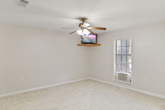 carpeted spare room with ceiling fan