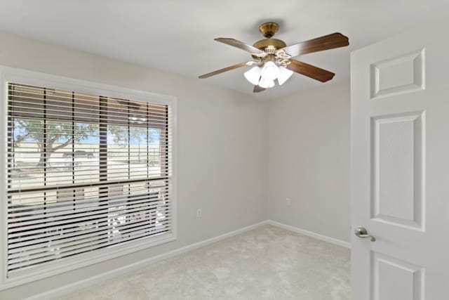 carpeted spare room with ceiling fan