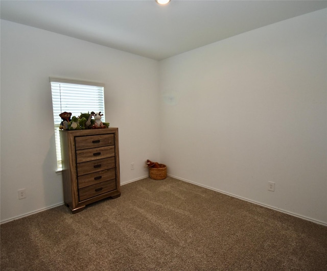 empty room featuring dark colored carpet