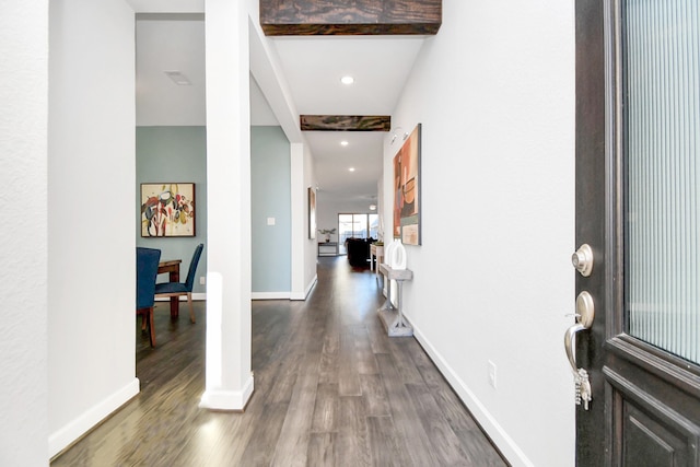 entryway with beamed ceiling and dark wood-type flooring