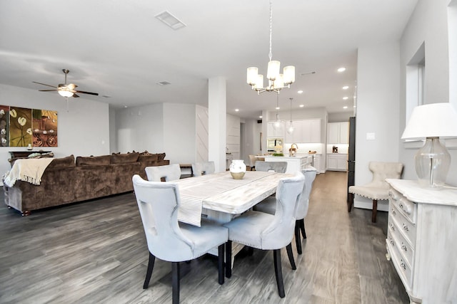 dining space featuring hardwood / wood-style floors and ceiling fan with notable chandelier