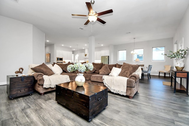 living room featuring hardwood / wood-style floors and ceiling fan with notable chandelier