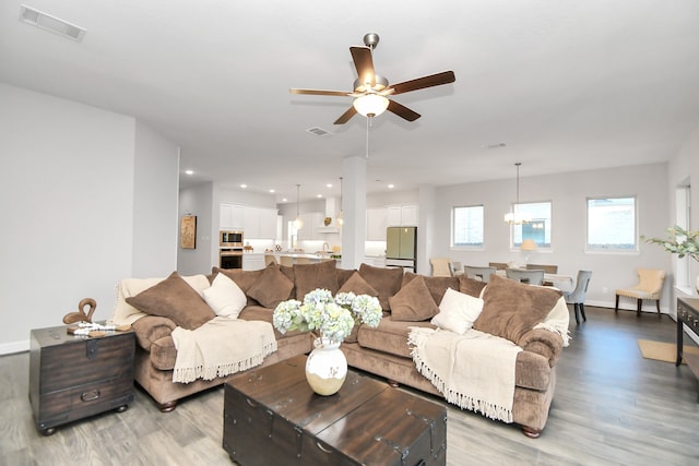 living room with light wood-type flooring and ceiling fan