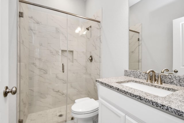 bathroom with vanity, toilet, and a shower with shower door